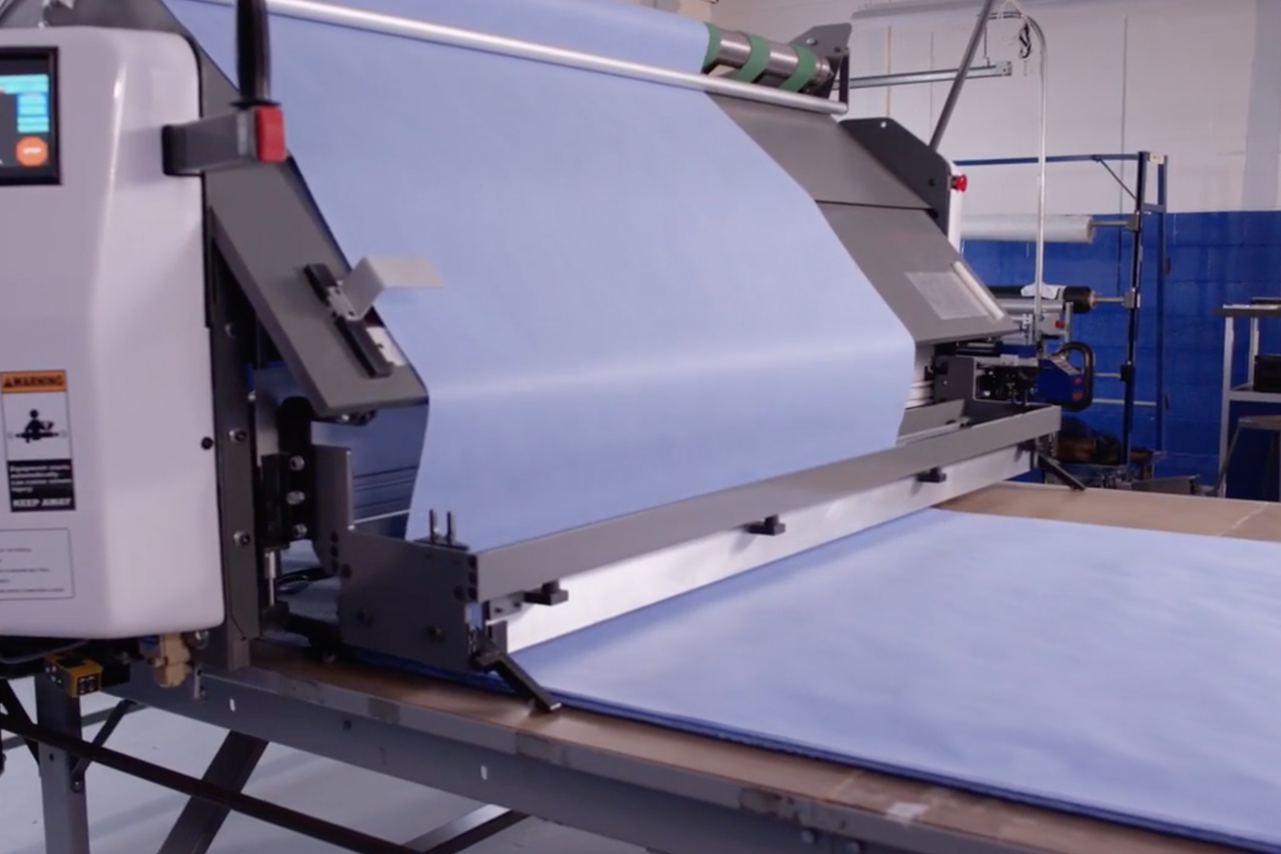 spreader places blue material on cutting surface