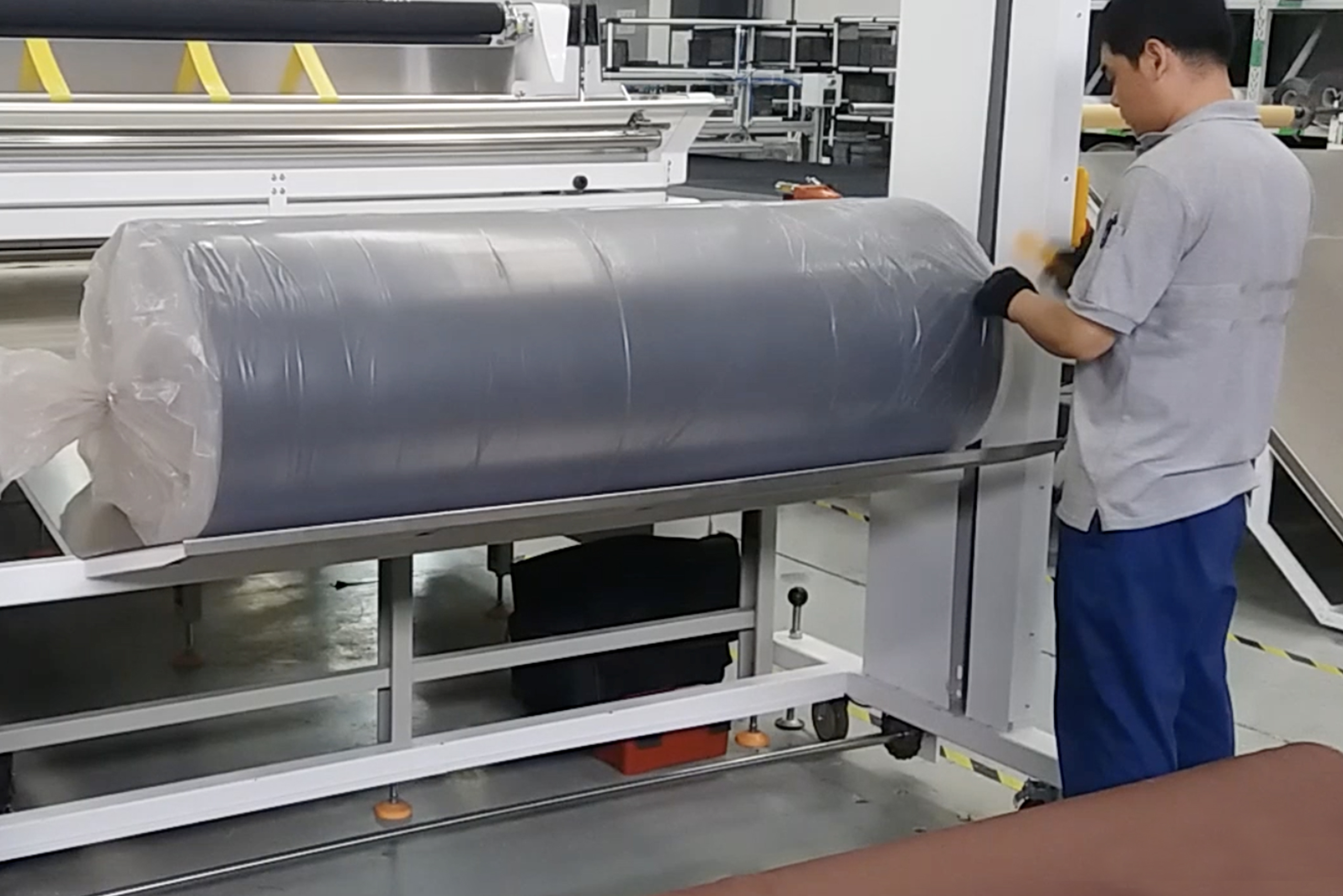 person loads fabric roll onto cutter with EFL 200