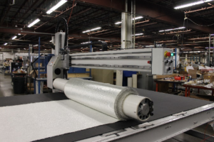 Roll of fiberglass fabric on cutting surface