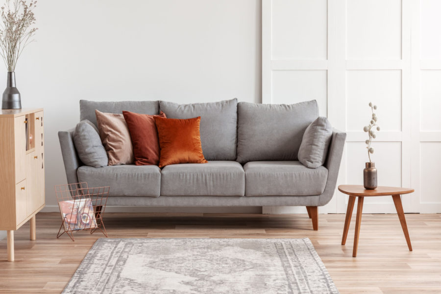 Grey couch with orange pillows