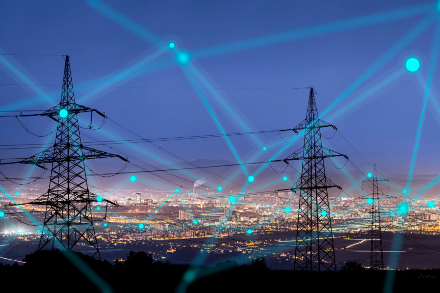 Utility poles with illuminated city in the background